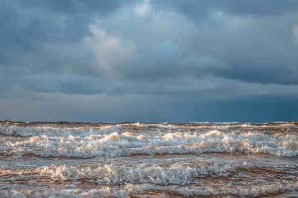 Deniz dalgalarında gün ışığı parlar. Rüzgar dalgaları kıyıya vurur. Kışın, toprak seti taşlarla kaplıdır.