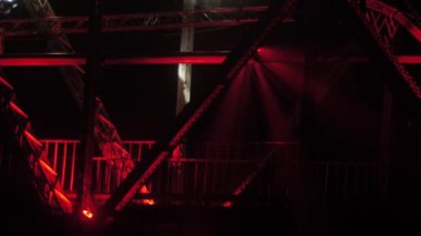 Eski demiryolu köprüsü aydınlandı. Köprüde ışık gösterisi. Geceleri ışıklar, sisli arka plan