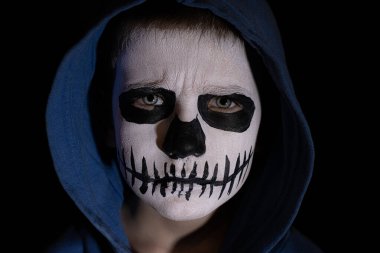 Tüm ölülerin maskeli çocuğu günü. Cadılar Bayramı makyajında gülümseyen korkutucu küçük çocuk..