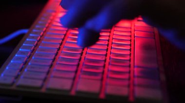 Parmaklar klavyede. Karanlık aydınlatma odası. Seçici odak