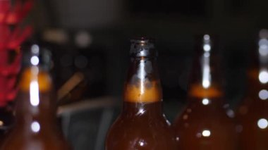 Bir kır evinde bira fabrikası. Kahverengi bira şişeleri taze birayla doludur.