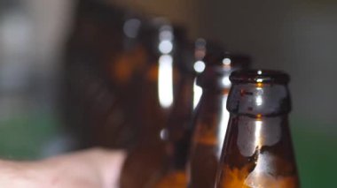 Bir kır evinde bira fabrikası. Kahverengi bira şişeleri taze birayla doludur.