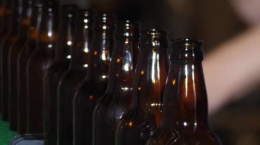 Bir kır evinde bira fabrikası. Kahverengi bira şişeleri taze birayla doludur.