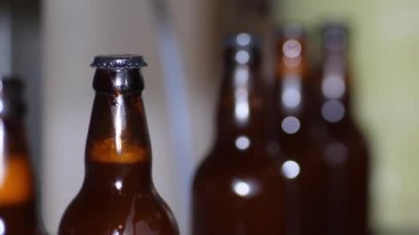 Bir kır evinde bira fabrikası. Kahverengi bira şişeleri taze birayla doludur.