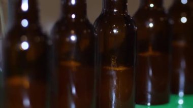 Bir kır evinde bira fabrikası. Kahverengi bira şişeleri taze birayla doludur.