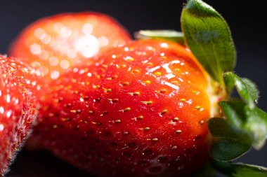 Çilek tohumları kapanıyor. Büyük, olgun çilekler. Yumuşak seçici odak