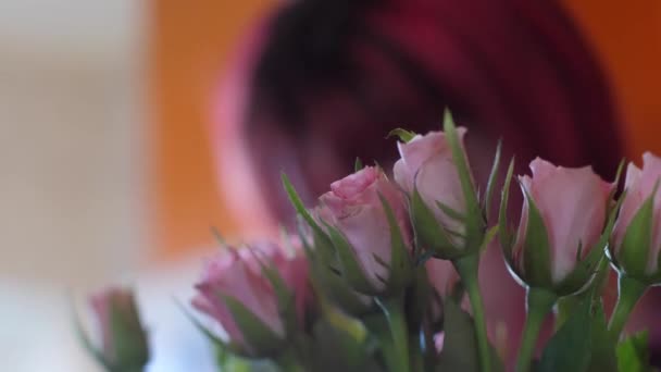 Una Mujer Con Pelo Rojo Está Detrás Hermosas Rosas Rosadas — Vídeo de stock