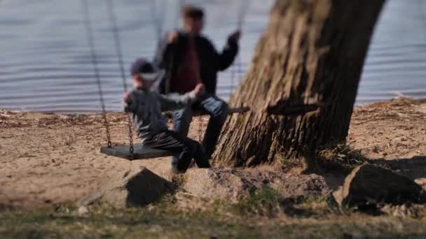 Children Rocked Swing Lake Faces Blurred Selective Focus — стоковое видео