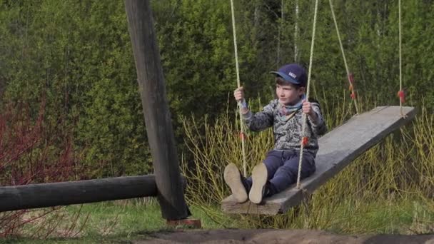 Dziecko Wielkim Huśtawce Chłopiec Siedzi Drewnianym Huśtawce — Wideo stockowe