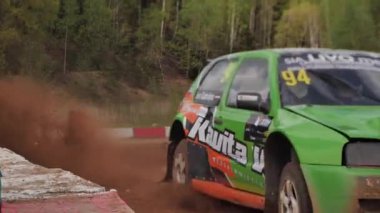 Çakıl taşı pistinde araba yarışı, yarışmaya katılarak birincilik için mücadele. Taşlar arabanın lastiklerinden uçuyor. Arabalar katılıyor. Brenguli.