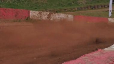 Çakıl taşı pistinde araba yarışı, yarışmaya katılarak birincilik için mücadele. Taşlar arabanın lastiklerinden uçuyor. Arabalar katılıyor. Brenguli.