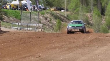 Çakıl taşı pistinde araba yarışı, yarışmaya katılarak birincilik için mücadele. Taşlar arabanın lastiklerinden uçuyor. Arabalar katılıyor. Brenguli.