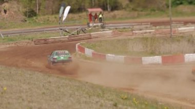 Çakıl taşı pistinde araba yarışı, yarışmaya katılarak birincilik için mücadele. Taşlar arabanın lastiklerinden uçuyor. Arabalar katılıyor. Brenguli.