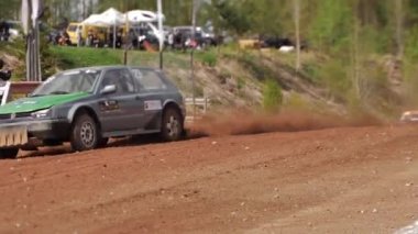 Çakıl taşı pistinde araba yarışı, yarışmaya katılarak birincilik için mücadele. Taşlar arabanın lastiklerinden uçuyor. Arabalar katılıyor. Brenguli.