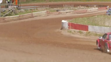 Çakıl taşı pistinde araba yarışı, yarışmaya katılarak birincilik için mücadele. Taşlar arabanın lastiklerinden uçuyor. Arabalar katılıyor. Brenguli.