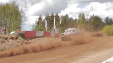 Çakıl taşı pistinde araba yarışı, yarışmaya katılarak birincilik için mücadele. Taşlar arabanın lastiklerinden uçuyor. Arabalar katılıyor. Brenguli.