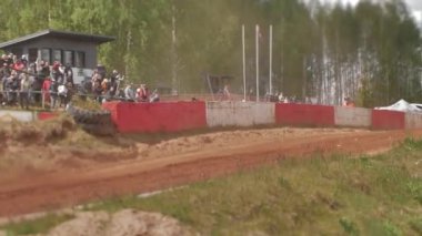 Çakıl taşı pistinde araba yarışı, yarışmaya katılarak birincilik için mücadele. Taşlar arabanın lastiklerinden uçuyor. Arabalar katılıyor. Brenguli.