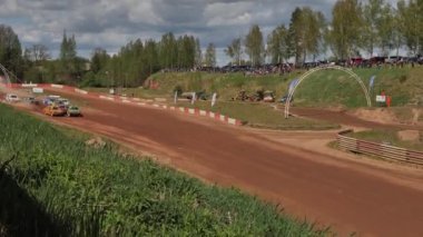 Çakıl taşı pistinde araba yarışı, yarışmaya katılarak birincilik için mücadele. Taşlar arabanın lastiklerinden uçuyor. Arabalar katılıyor