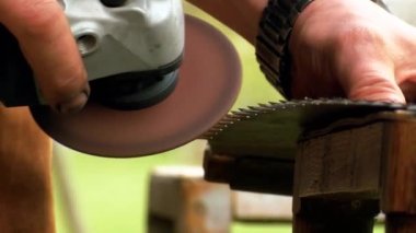 Eski paslı el testereleri keskinleştirilir. Testereden kıvılcımlar çıkıyor