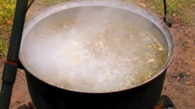 Çorba eski bir tencerede ateşte kaynar. Çorba tenceresi ateşte.