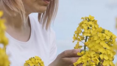 Kadın tecavüz sahasında yürüyordu. Tecavüz alanında bir kız. Çiftçi yağ tohumu tecavüzü yetiştiriyor