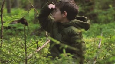 Çocuk ormanda tek başına kayboldu. Ormandaki çocuk yalnız. Ormanda tek başına hayatta kalmak. Bir turist çocuk çalılıklarda kayboldu. Üzgün bir çocuk bulunmayı bekliyor. Seçici odak