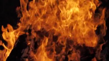 Siyah arka planda yangın alevi. Ateş alevi karanlıkta dans eder. Yumuşak sinema filmi. Ekranda güçlü alevler var. Yumuşak seçici odak.