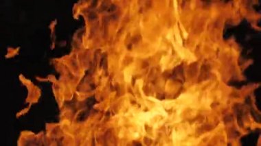 Siyah arka planda yangın alevi. Ateş alevi karanlıkta dans eder. Yumuşak sinema filmi. Ekranda güçlü alevler var. Yumuşak seçici odak.