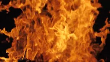 Siyah arka planda yangın alevi. Ateş alevi karanlıkta dans eder. Yumuşak sinema filmi. Ekranda güçlü alevler var. Yumuşak seçici odak.
