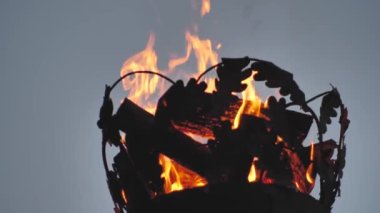 Ateşli bir sütunda taç. Bir direğin üzerindeki yangına yakın çekim. Sinematografik bir resim. Nesnelere odaklanın. Letonya Yaz Gecesi Ligo 'da Pagan şenlik ateşi festivali. Yaz ortası şenlik ateşi..