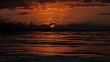Golden sunset in the sky. Reflection of sunlight on the surface of clouds. Beautiful yellow evening shot. Setting sun behind the clouds. Majestic sunset scenery. Amazing nature light cloudy sky.