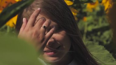 Beautiful woman with long hair in a sunflower meadow. A girl in a beautiful meadow with yellow flowers.