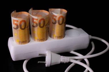 Elektrik tüketicileri için pahalı. Avro banknotlarının elektrik prizleri siyah arka planda. Pahalı elektrik maliyeti kavramı ve enerji faturası fiyatlarındaki artış.