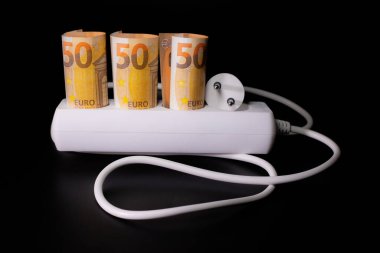 Elektrik tüketicileri için pahalı. Avro banknotlarının elektrik prizleri siyah arka planda. Pahalı elektrik maliyeti kavramı ve enerji faturası fiyatlarındaki artış.
