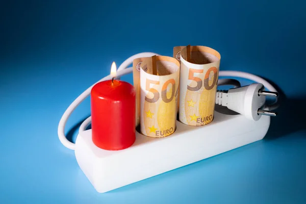 Energy price increase. Burning candles with a euro banknote. Increase in energy bill prices.