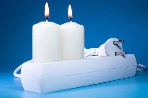 Energy price increase. Burning candles in an electrical extension cord. Increase in energy bill prices.