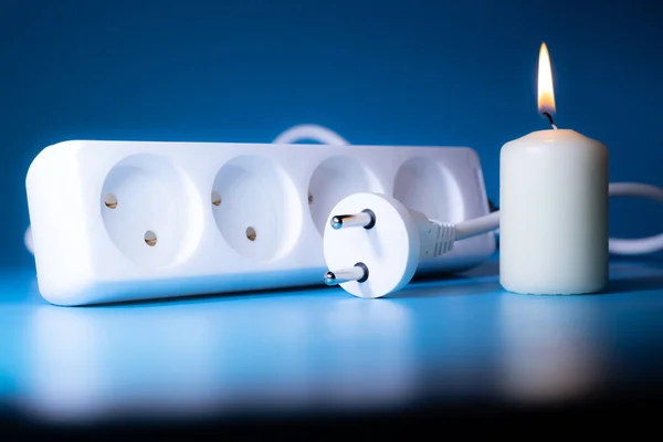 Energy price increase. Burning candles in an electrical extension cord. Increase in energy bill prices.