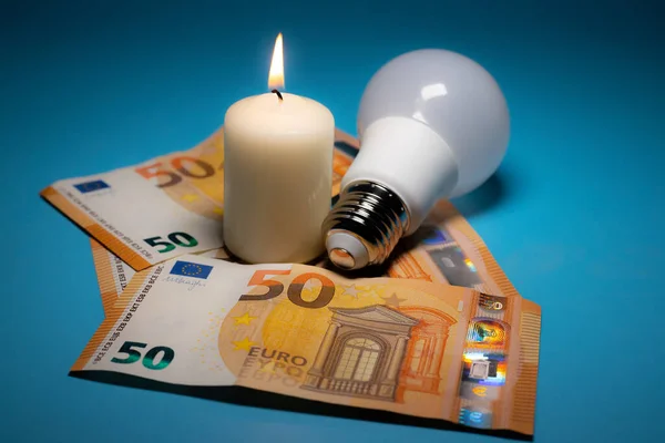 Energy price increase. Burning candles with an incandescent bulb on euro money. Increase in energy bill prices.