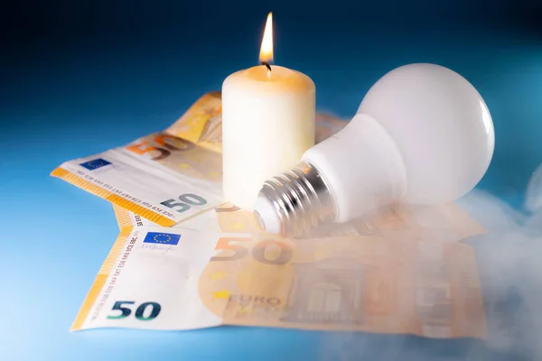 Energy price increase. Burning candles with an incandescent bulb on euro money. Increase in energy bill prices.