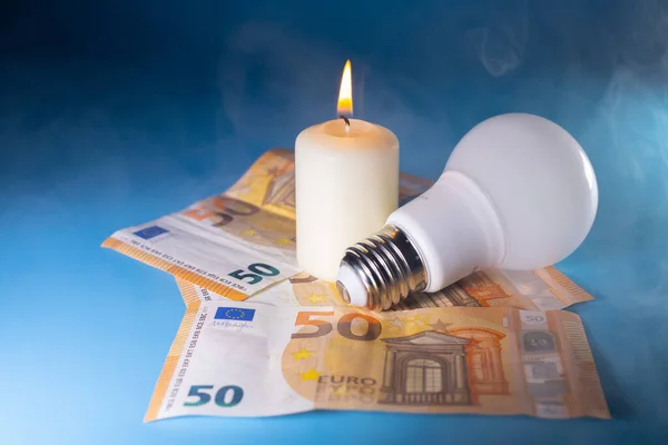 Energy price increase. Burning candles with an incandescent bulb on euro money. Increase in energy bill prices.