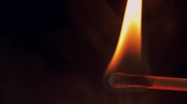 Dumanda yanan bir kibrit. Yangının kaynağı. Dikkatsizce ateş etme.