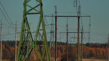 Mavi gökyüzünde güneş ışınları olan elektrik hatları. Yüksek voltaj santrali. Dünya 'da elektrik krizi. Elektrik hatlarında yeşil enerji. Seçici yumuşak odak