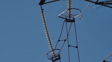 Mavi gökyüzünde güneş ışınları olan elektrik hatları. Yüksek voltaj santrali. Dünya 'da elektrik krizi. Elektrik hatlarında yeşil enerji. Seçici yumuşak odak