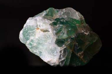 Siyah yüzeyde izole edilmiş kaba yeşil flüorit taş parçasının makrosu