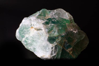 Siyah yüzeyde izole edilmiş kaba yeşil flüorit taş parçasının makrosu