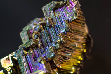 Bismuth bi kara yüzey üzerindeki doğal bir element izole edilmiş makroyu kapatır. İlginç bir yapı, renk ve şekil kristali. Metal kristal