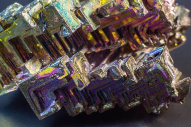 Bismuth bi kara yüzey üzerindeki doğal bir element izole edilmiş makroyu kapatır. İlginç bir yapı, renk ve şekil kristali. Metal kristal