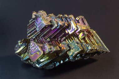 Bismuth bi kara yüzey üzerindeki doğal bir element izole edilmiş makroyu kapatır. İlginç bir yapı, renk ve şekil kristali. Metal kristal