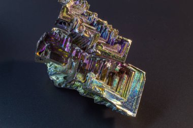 Bismuth bi kara yüzey üzerindeki doğal bir element izole edilmiş makroyu kapatır. İlginç bir yapı, renk ve şekil kristali. Metal kristal