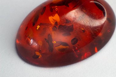 Beyaz bir yüzeye izole edilmiş dairesel içerikli koyu turuncu kehribar karyola.